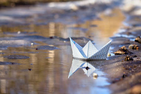 Toy boat of paper in the water の写真素材