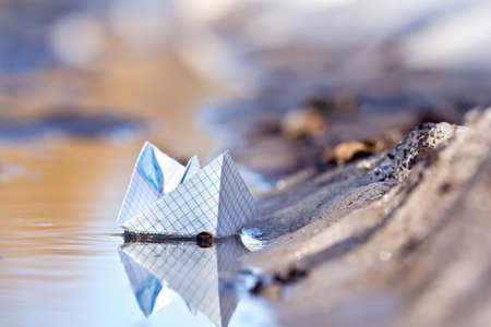 Toy boat of paper in the water の写真素材