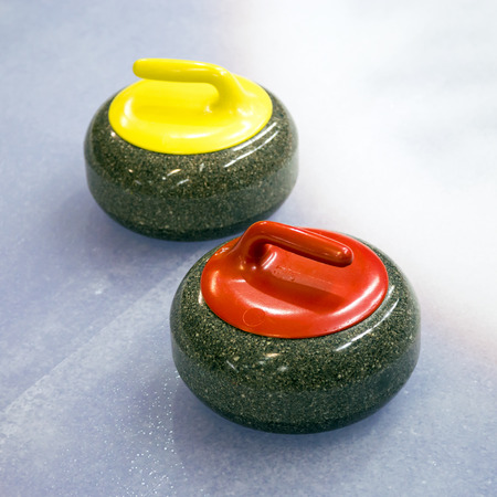 A two curling stone on the ice of a curling rinkの写真素材