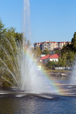 Rainbow in the fountain. Komsomolskiy pond with Fountains in sunny day, Lipetsk, Russiaの写真素材