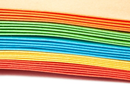 A stack of bright colored paper envelopes
