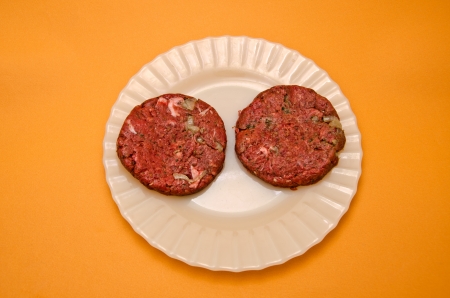 Dish with raw hamburgersの写真素材