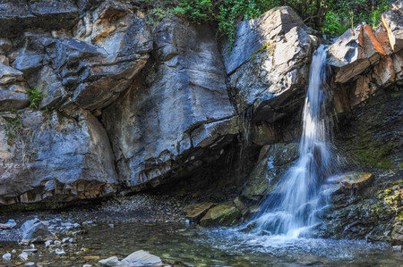 Rainbow Falls in a small Rock pileの写真素材