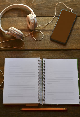 space to write with notebook, phone and headphones on wood, space for inspiration, verticalの写真素材