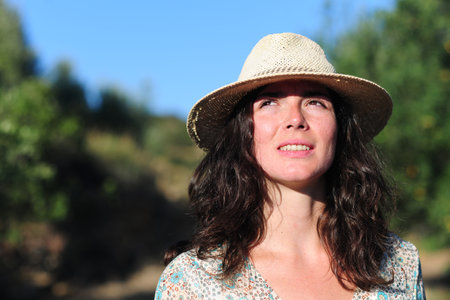 Portrait of a beautiful woman in a straw hat on a sunny dayの写真素材