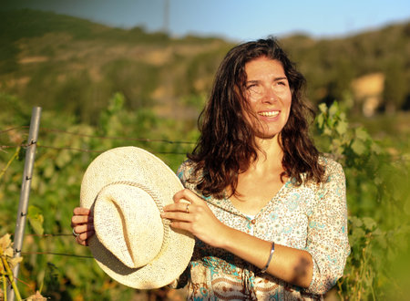 Portrait of a beautiful young woman with hat in the vineyardの写真素材