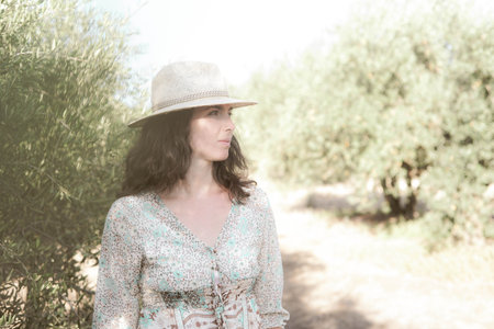 Portrait of a beautiful woman in a straw hat on a sunny dayの写真素材