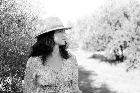 Portrait of a beautiful woman in a straw hat on a sunny dayの写真素材