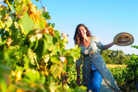 Portrait of a beautiful young woman with hat in the vineyardの写真素材