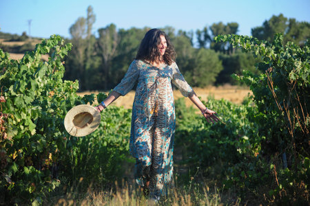 Portrait of a beautiful young woman with hat in the vineyardの写真素材