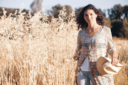 Beautiful young woman in the wheat field. Selective focus.の写真素材