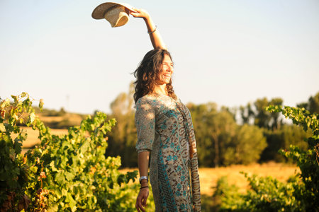 Portrait of a beautiful young woman with hat in the vineyardの写真素材