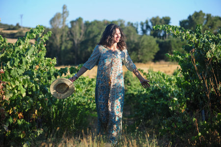 Portrait of a beautiful young woman with hat in the vineyardの写真素材