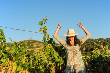 Portrait of a beautiful young woman with hat in the vineyardの写真素材