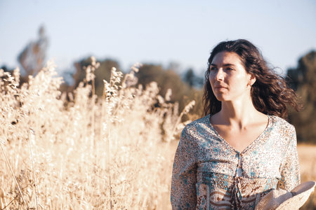 Beautiful young woman in the wheat field. Selective focus.の写真素材