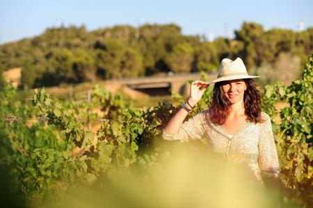 Portrait of a beautiful young woman with hat in the vineyardの写真素材