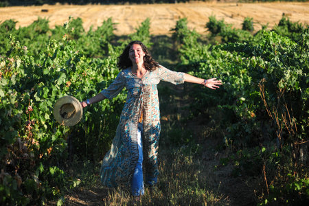 Portrait of a beautiful young woman with hat in the vineyardの写真素材