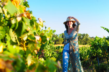 Portrait of a beautiful young woman with hat in the vineyardの写真素材