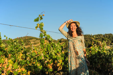 Portrait of a beautiful young woman with hat in the vineyardの写真素材