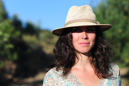 Portrait of a beautiful woman in a straw hat on a sunny dayの写真素材
