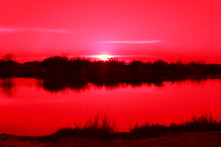 A red sunset over the Aransas River in Texas.の写真素材