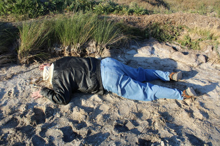 A man in a black leather jacket on the beach.の写真素材