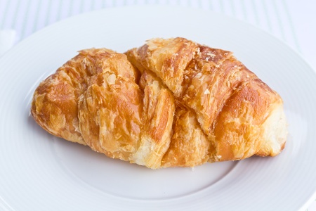 The fresh croissant isolated on white plateの写真素材