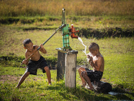 Two young boy rocking groundwater bathe in the hot days, Countryside Thailand.の写真素材