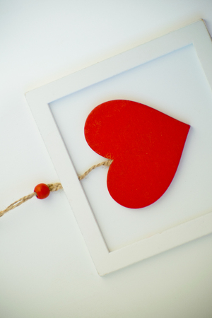 Red heart on a rope in the wooden frame. Valentines day.の写真素材