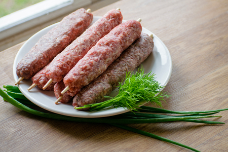 Raw lulya kebab from meat on a white plate.の写真素材