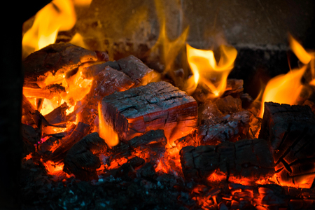 Crest of flame on burning wood in fireplace.の写真素材