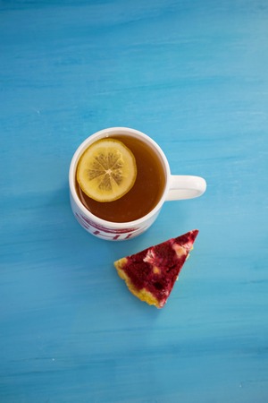 Cheesecake with raspberries and black tea with lemon close-up. Tasty light breakfast.の写真素材