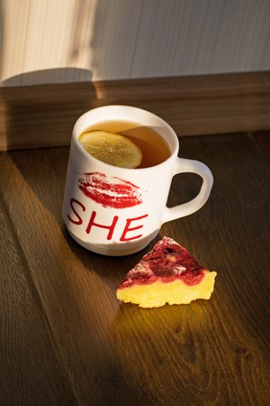 Cheesecake with raspberries and black tea with lemon close-up. Tasty light breakfast.の写真素材