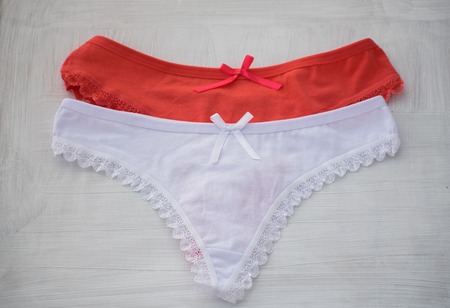 Delicate red and white lingerie. Red and white lace thong on white background.