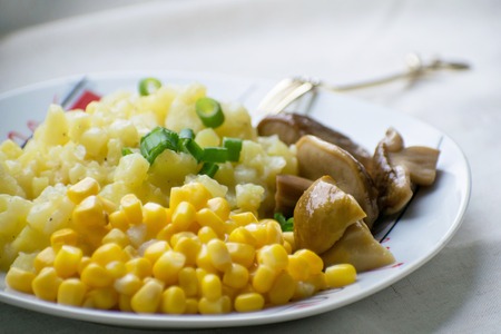 Fried potatoes with pickled mushrooms and corn.の写真素材