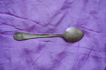 Silver set against the violet background. Antique style silver fork and spoonの写真素材
