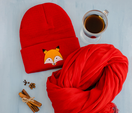Warm scarf, hat, cinnamon sticks, anise stars and coffee. Autumn and winter concept. Cup of hot coffee or tea with spices.の写真素材