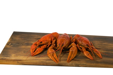 Red boiled crayfish food on wooden board on white background.の写真素材
