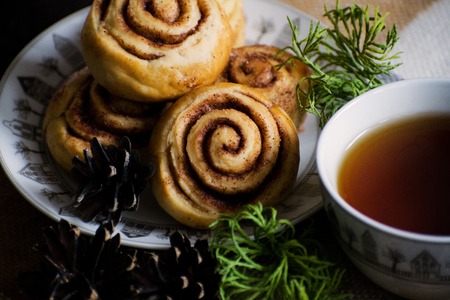 Cinnamon rolls buns with spices . Cinnamon cookie with tea on christmas backgroundの写真素材