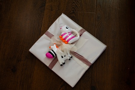 Gift tied with a bow for a newborn with rattles Gift for newborn, birthday. Bright rattles for baby.の写真素材