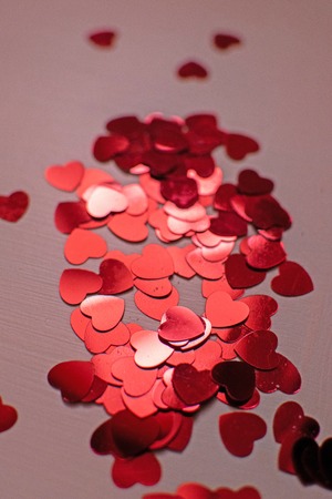 Red hearts. Heart confetti on pink background, glitter background. Color of the year 2019 - living...