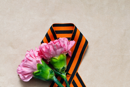 Carnation and St. George ribbon on craft background, symbol of the great Victory, victory day, 9 May backgroundの写真素材