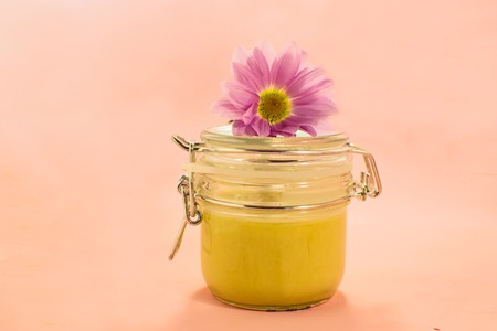 Wax honey for epilation. Shugaring. Removing hair. Cosmetics. Honey in jar with flower on Living...