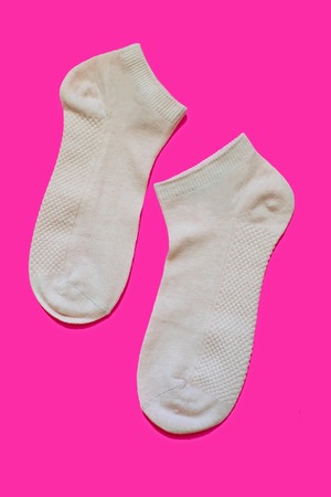 Pair of women's sport socks on bright pink background