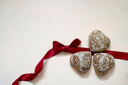 Three gingerbread gingerbread in white glaze on pink background with copy space.の写真素材
