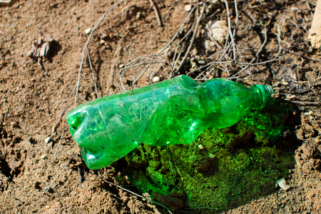 Wrinkled plastic bottle on the ground. Plastic garbage. Environmental pollution.の写真素材