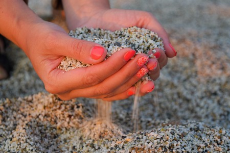 Young woman with sand in handsの写真素材