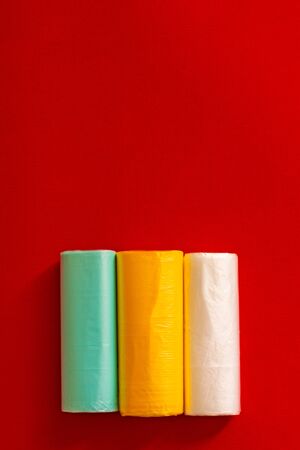 Three colored garbage bags roll on gray backgroundの写真素材