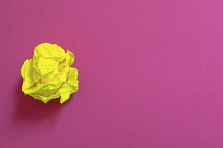 Crumpled sheet of yellow paper on on color background.の写真素材