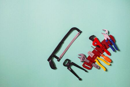 Children's toy plastic tools builder and carpenter. Children's tool: screwdriver, pliers, clamp, adjustable wrench and handsaw. Selective focus.の写真素材